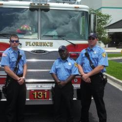 firefighters posing in front of firetruck